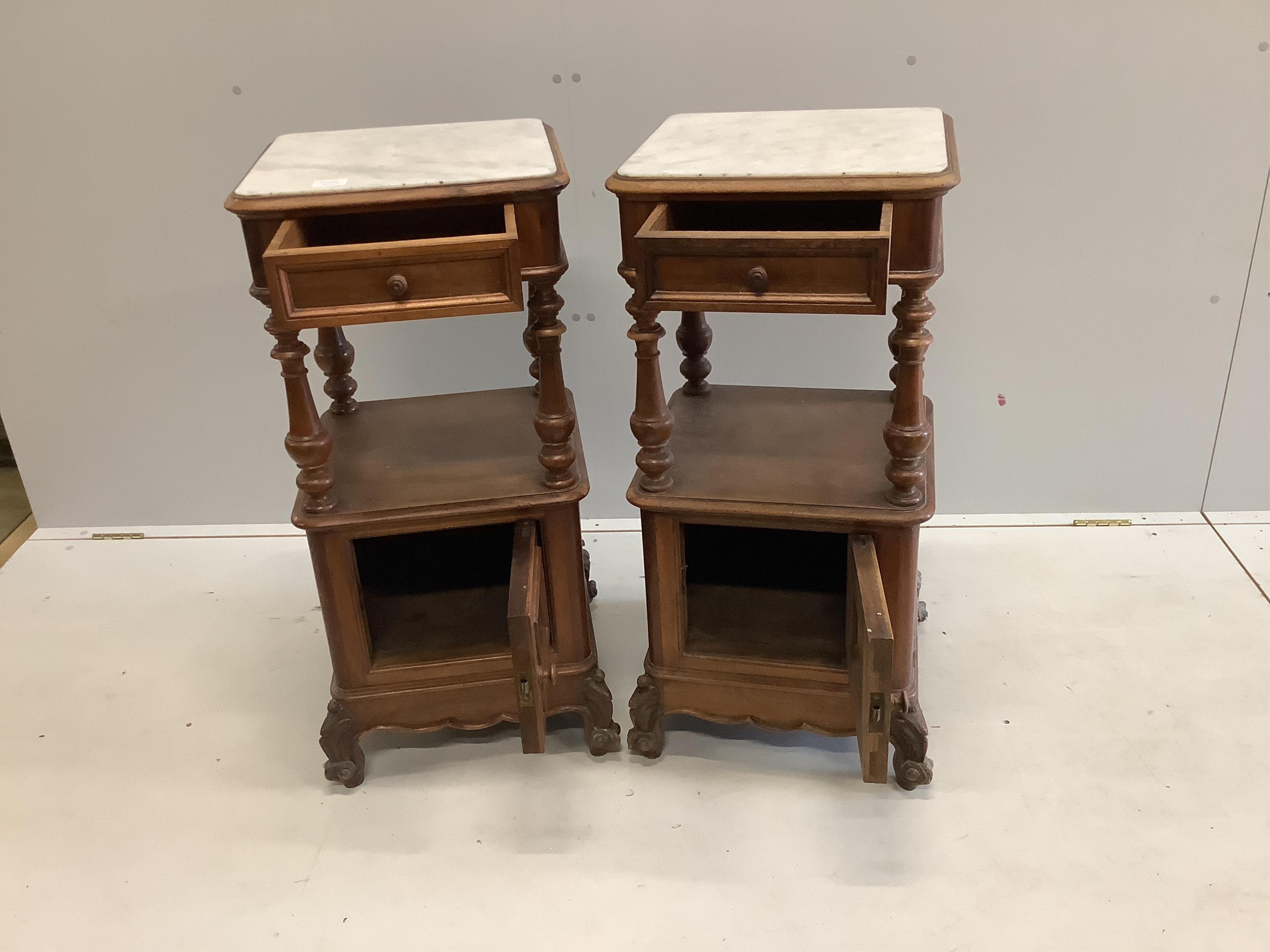 A pair of late 19th / early 20th century French marble top walnut two tier bedside cabinets, width 41cm, depth 41cm, height 89cm. Condition - fair